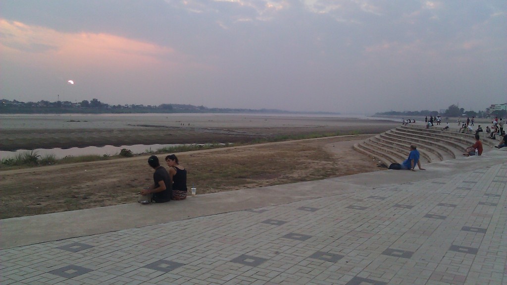 people sitting on the ground near a large field
