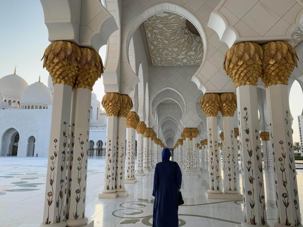 walking around in an abaya at Sheikh Zayed Grand Mosque in Abu Dhabi during the golden hour before sunset