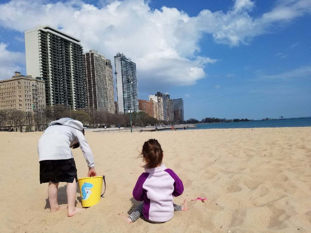 a kid and a toddler on the beach in Chicago