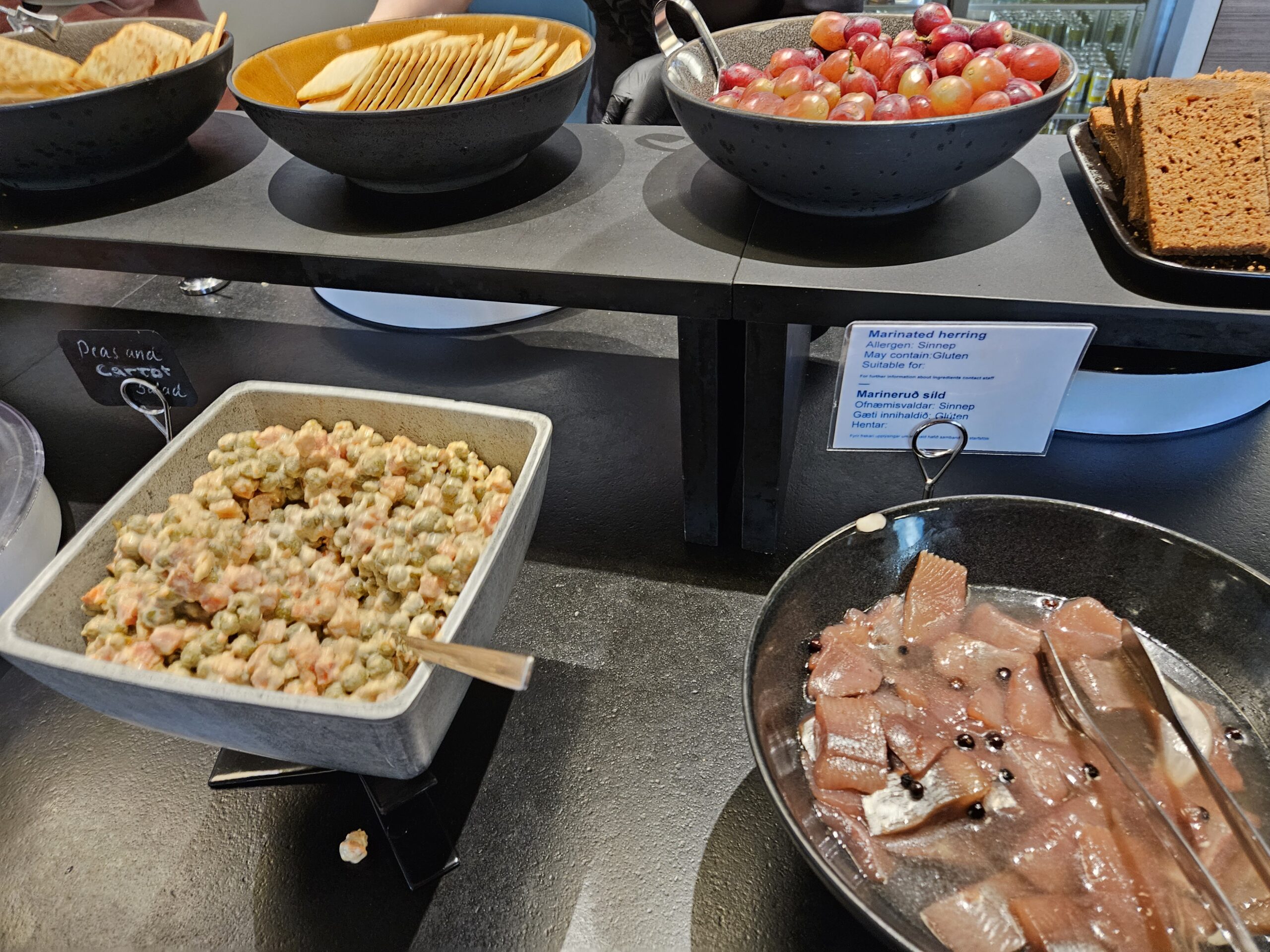 a buffet table with bowls of food in Icelandair Saga business class lounge